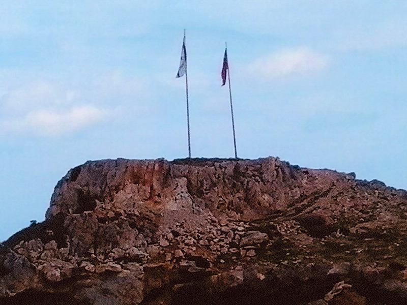 Turkish and Republic of North Cyprus Flags over Aphrodite’s Cave Entrance, photo © Lisa Streitfeld, 2017