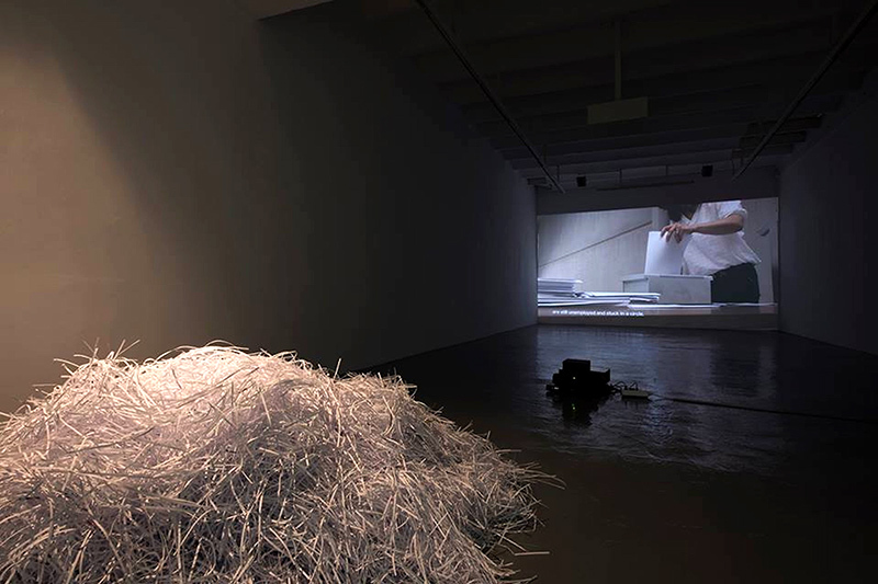 Línea de producción por excedente : Papier découpé et vidéo monocanale, couleur, oeuvre de l'artiste Adrian Melis