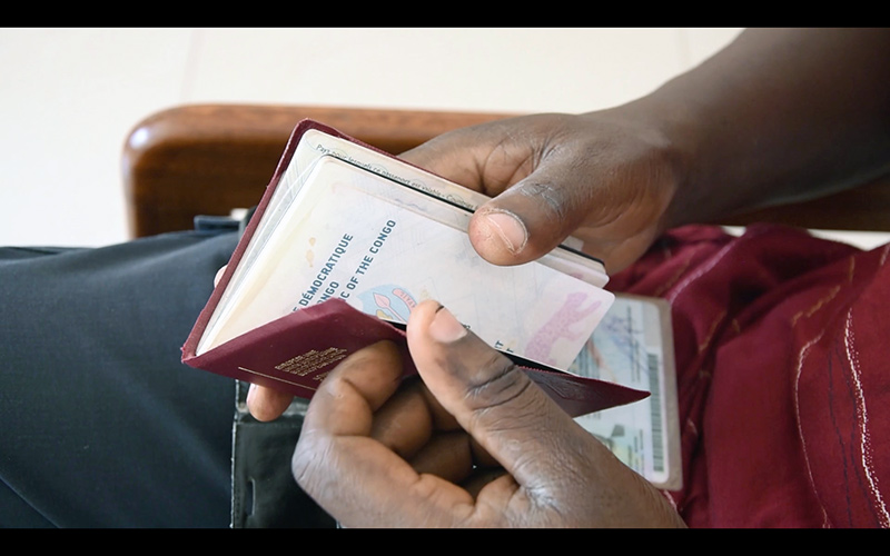 Younes Baba Ali, Arrival/Departure, 2019. Installation comprenant une vidéo, des couvertures de passeports et un stand de vente. Dimensions variables. Courtesy de l’artiste.