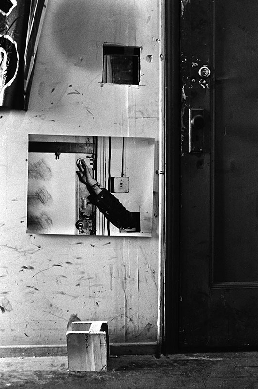 Gordon Matta-Clark Ouverture pratiquée dans le mur d’entrée et auprès de laquelle Matta-Clark a placé la photographie d’un bras, qui semble sortir du trou pour atteindre la serrure de la porte. About 405 East 13th Street #2, exposition collective, New York, 1974